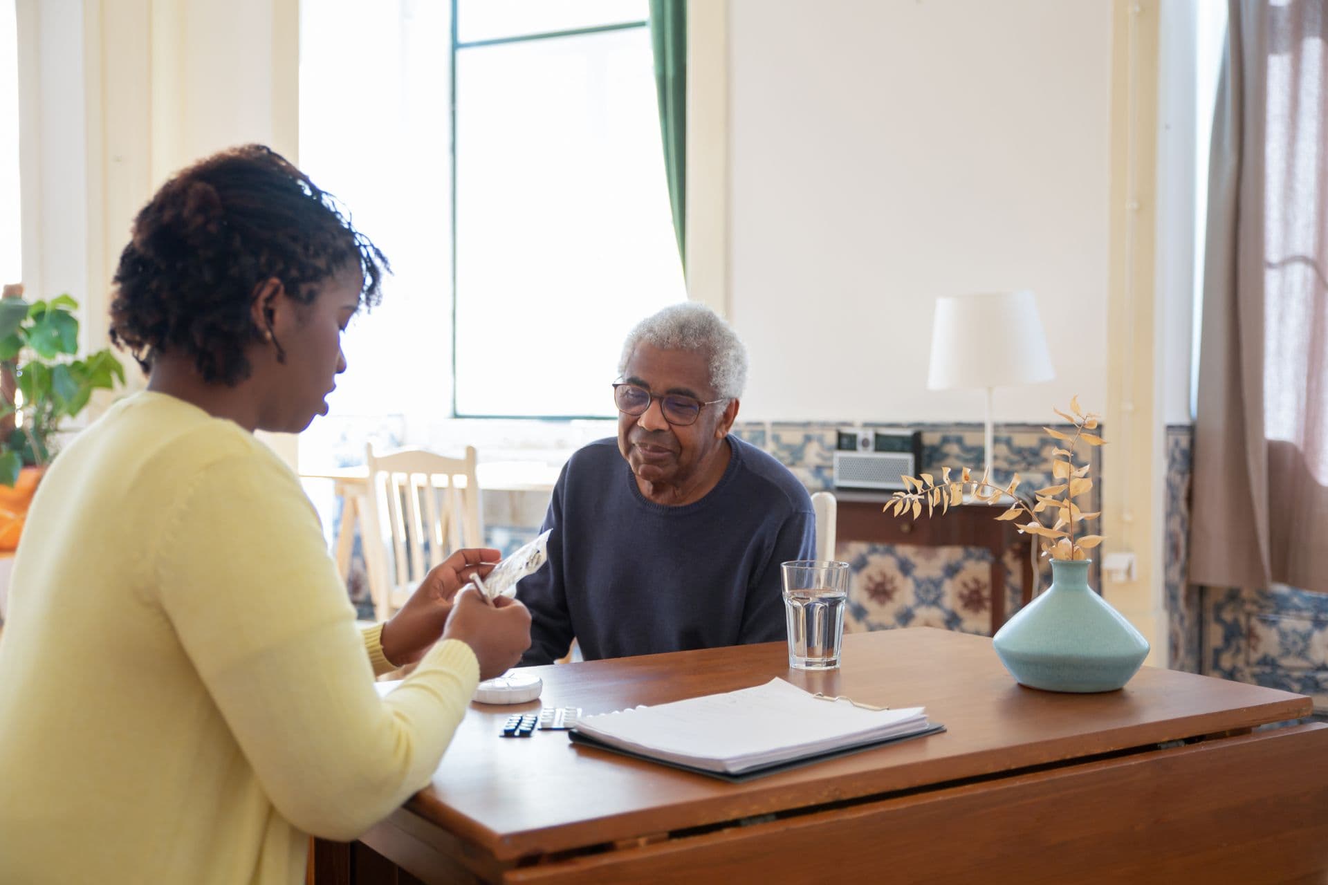 Caregiver warmly assisting a senior client at home